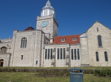 Old church with clock tower. Litter bin in front